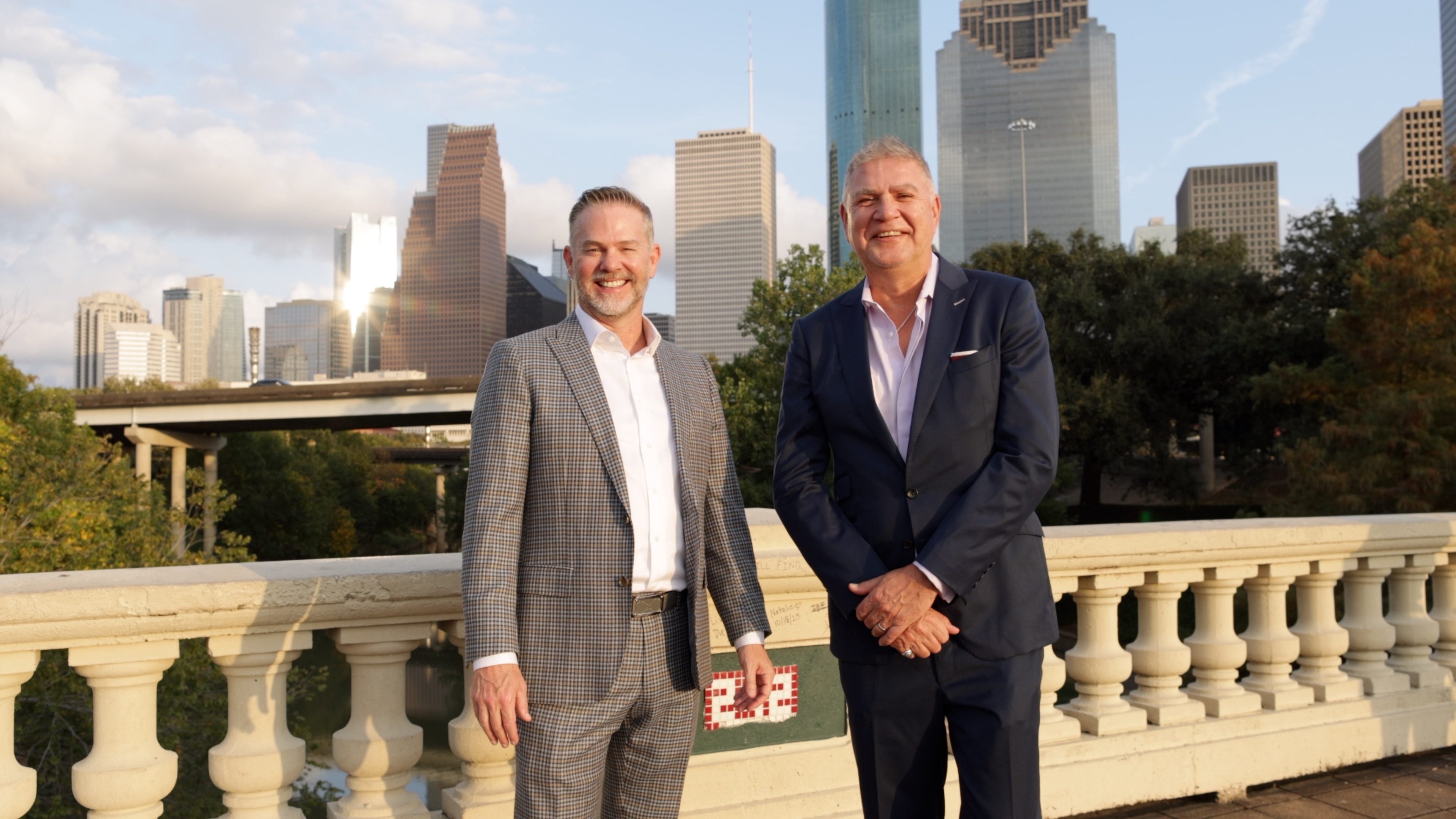 Two attorneys standing together with a city skyline in the background.